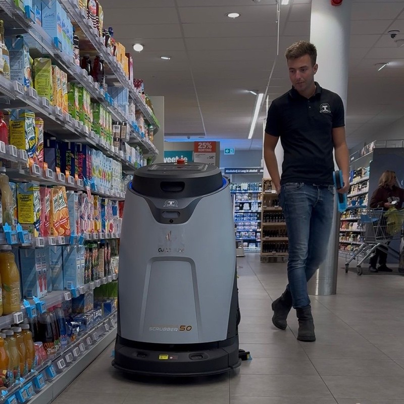 Luca Tesselaar met zijn schoonmaakrobot in de supermarkt